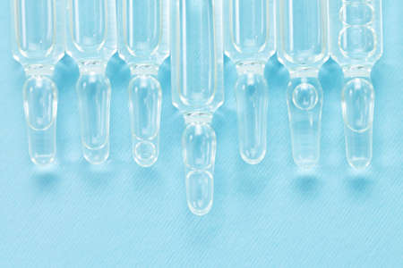 Background of glass medical vials with liquid. Medicine ampoules top viewの写真素材