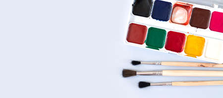 Paint brushes with used watercolor paint palette overhead view with copy spaceの写真素材
