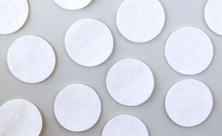 Set of white soft cleansing cotton pads or discs on gray table top view. Pattern backgroundの写真素材