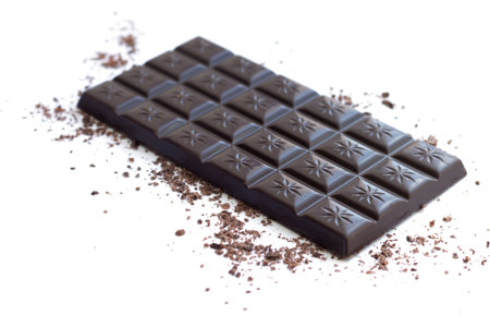 Dark chocolate bar with shavings and powder isolated on white background