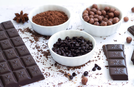 Bowls of ingredients for cooking chocolate or dessert isolated on white background side view