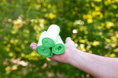 Man holding eco plastic garbage bio bags in rolls outdoorsの写真素材