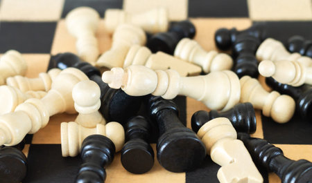 Heap of black and white chess pieces on chess board top view