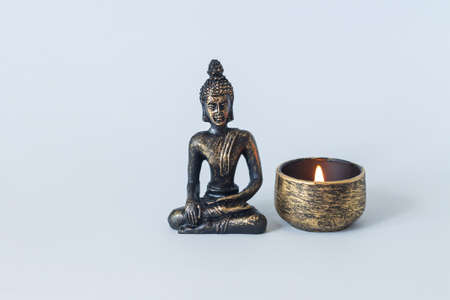 Buddha statue on altar with burning candle. Meditation, buddhism and enlightenment conceptの写真素材