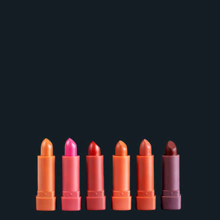 Set of fashion lipsticks palette in red, brown and pink colors, studio photo on black background. Beautiful make-up or cosmetic sale conceptの写真素材