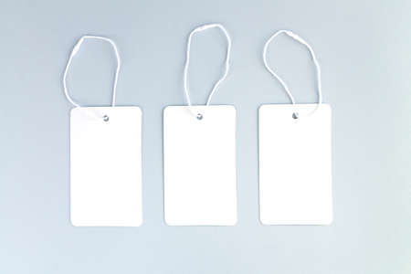Set of three blank white paper cloth labels or price tags on gray backgroundの写真素材