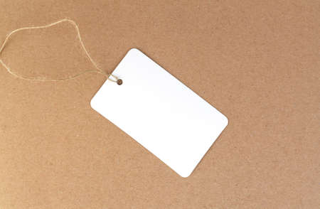 One blank white paper cloth label or price tag on brown backgroundの写真素材