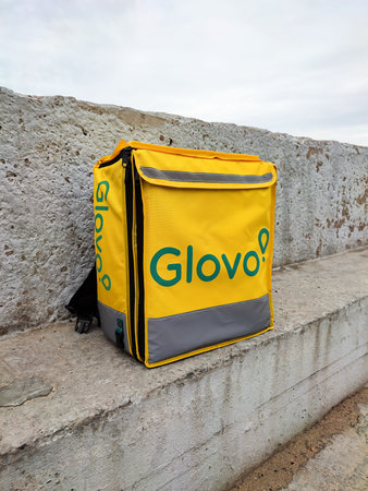 Kyiv, Ukraine - September 21, 2021: Glovo delivery food bag or thermobag outdoors. Delivery service...