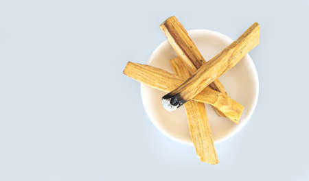 Palo santo holy wood on white ceramic plate top view. Meditation, healing, spiritual practices conceptの写真素材