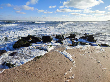 Blue cloudy sky and beautiful waves in the seaの写真素材