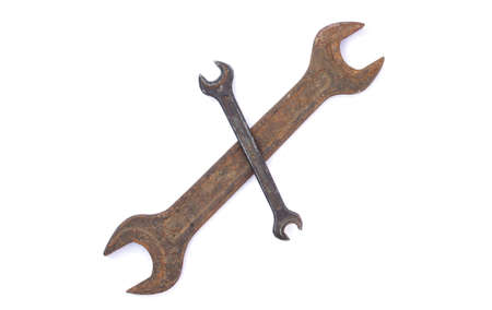 Two old rusty crossed wrenches isolated on white backgroundの写真素材