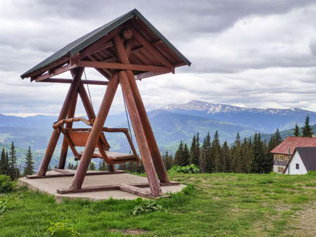 Beautiful wooden swing or bench in mountain valleyの写真素材