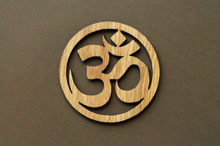 Wooden Om or Aum symbol of Hinduism and Buddhism on brown backgroundの写真素材