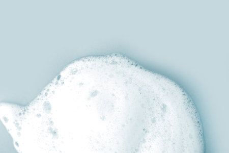 Skin care cleanser mousse foam texture. Soap, shower gel shampoo foam bubbles on light blue backgroundの写真素材
