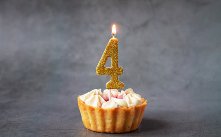 Number four birthday burning candle on tasty cupcakeの写真素材