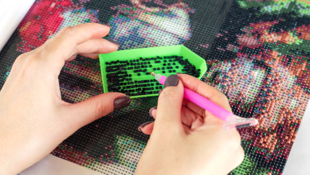 Woman collect diamond painting or diamond mosaic close-upの写真素材