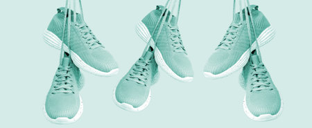 Group of light green female sport sneakers for run or fitness hanging on green background