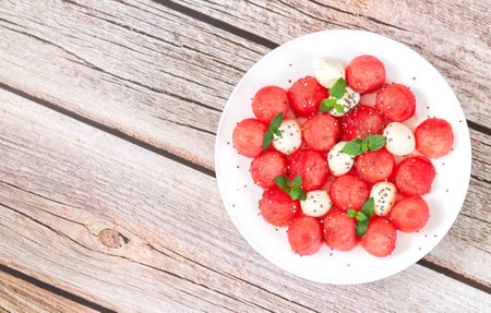 Summer season fruit salad with watermelon, mozzarella cheese, mint leaves and chia seeds. top viewの写真素材