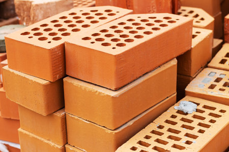 Heap of new red clay bricks for building construction