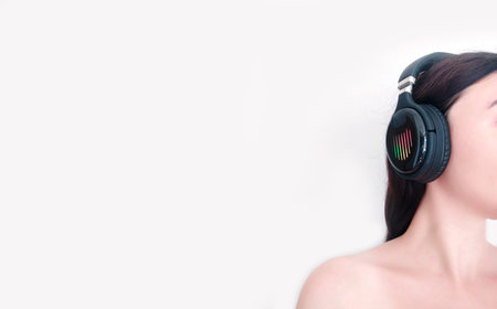 Brunette woman in wireless headphones listening musicの写真素材