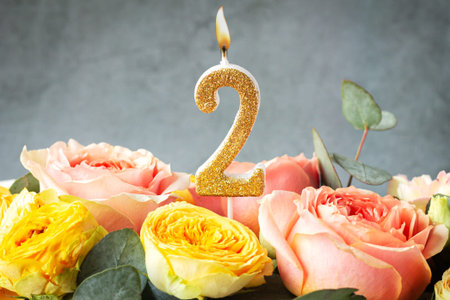 Gold glitter number 2 celebration candle with flowersの写真素材