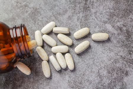 Medical pills spilling out of open drug bottleの写真素材