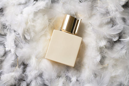 Perfume golden square bottle mockup on light feather backgroundの写真素材