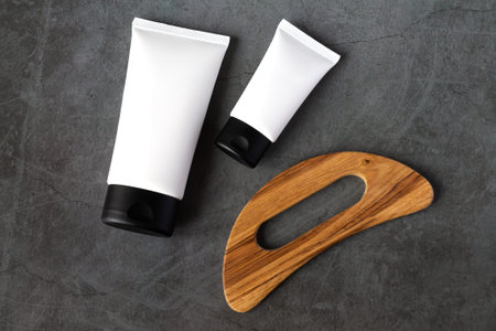 Set of anticellulite wooden massager, moisturizing cream and scrub for spa procedureの写真素材