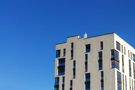 Modern apartment building on blue sky backgroundの写真素材