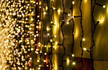 Christmas garlands glow in the dark on the background of colorful wall
