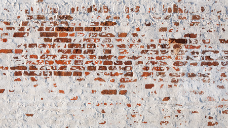 Texture of old brick wall with peeling plaster. Beautiful background of old brickwork of the historic building.の写真素材