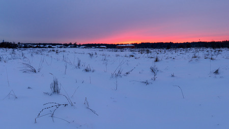 Panorama winter of red sunset over the snow-covered village.の写真素材