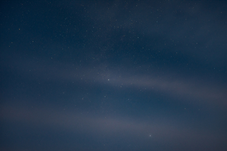 Starry sky through the cloudsの写真素材