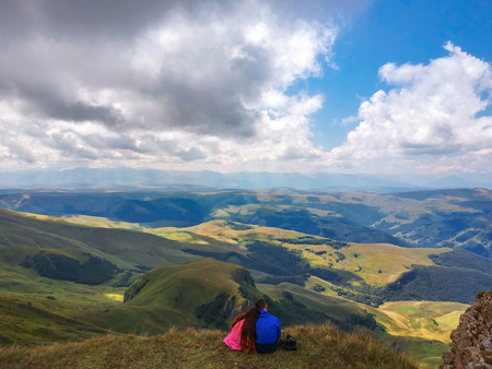 Couple in love sitting on a cliff of a mountain plateau, the view from the quadrocopterの写真素材