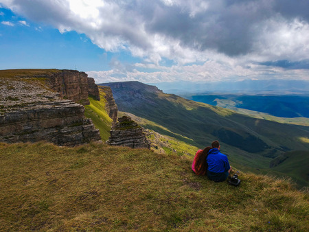 Couple in love sitting on a cliff of a mountain plateau, the view from the quadrocopterの写真素材