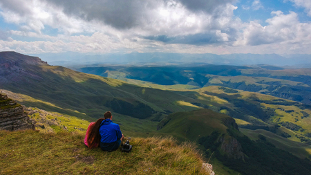Couple in love sitting on a cliff of a mountain plateau, the view from the quadrocopterの写真素材