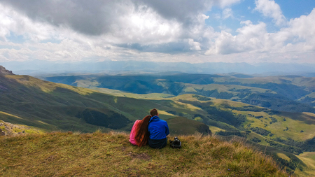 Couple in love sitting on a cliff of a mountain plateau, the view from the quadrocopterの写真素材