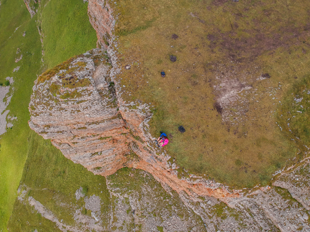 Couple in love sitting on a cliff of a mountain plateau, the view from the quadrocopterの写真素材