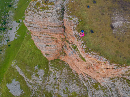 Couple in love sitting on a cliff of a mountain plateau, the view from the quadrocopter