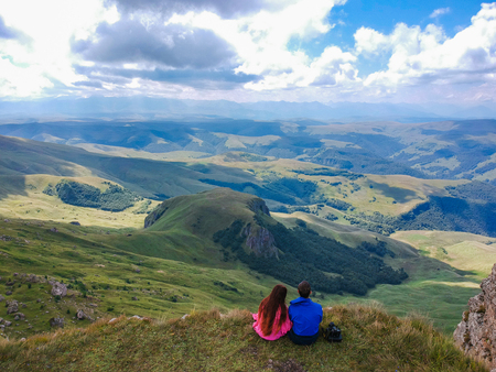 Couple in love sitting on a cliff of a mountain plateau, the view from the quadrocopterの写真素材
