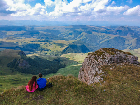 Couple in love sitting on a cliff of a mountain plateau, the view from the quadrocopterの写真素材