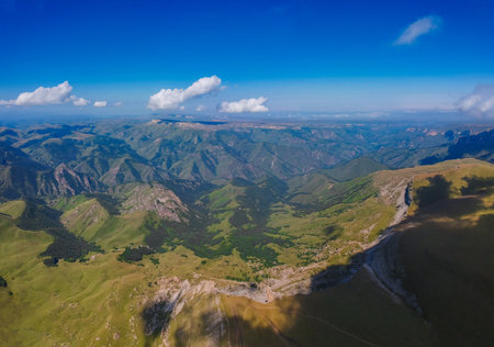 Mountains with high altitude quadrocopter in summer, clouds and fields around