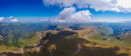 Mountains with high altitude quadrocopter in summer, clouds and fields aroundの写真素材