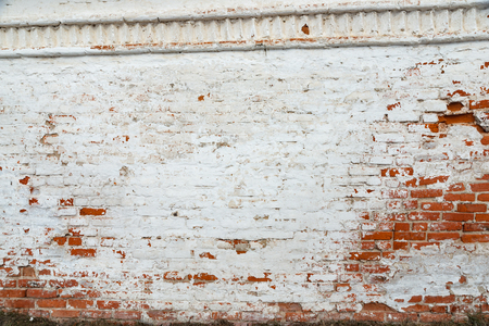 The texture of the old brick wall painted white with peeling paintの写真素材