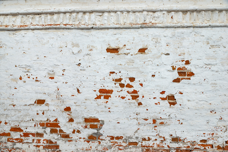The texture of the old brick wall painted white with peeling paintの写真素材
