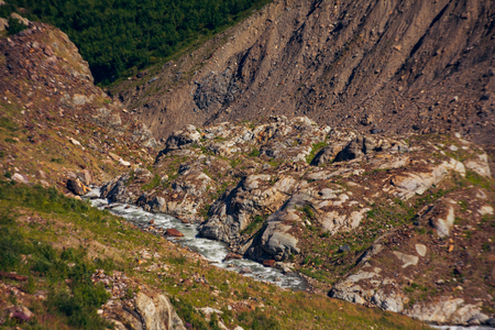 Brooks flow from the mountain in the surroundings of Dombai. The Caucasus Mountains on a summer, clear day. Tourie Lake.の写真素材