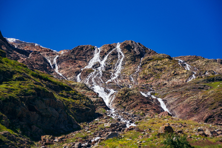 Brooks flow from the mountain in the surroundings of Dombai. The Caucasus Mountains on a summer, clear day. Tourie Lake.の写真素材