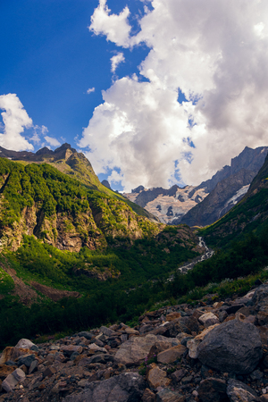 Massive peaks of the Caucasus Mountains in the snow in the surroundings of dombai in the clouds. Summer day.の写真素材