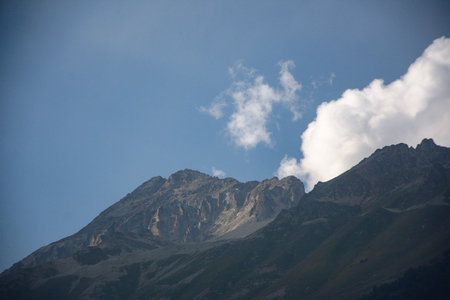 Large panorama Massive Caucasian mountains in the surroundings of dombai in the clouds. Summer day.の写真素材