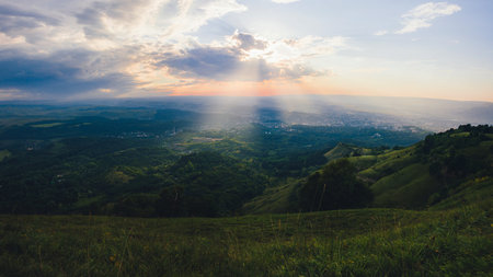 Sunset over Kislovodsk from a height in summer, the rays of the sun through the clouds.
